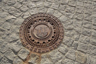 Manhole cover with city coat of arms, paving stones, soil, sewerage, Freiberg, Freiberg, Saxony,