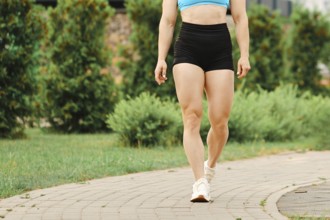 Muscular legs of female bodybuilder walking