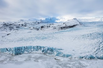 Snow-covered icebergs in the Fjallsarlon glacier lagoon, with the Öraefajökull glacier behind,