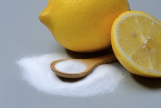 Citric acid in wooden spoon and lemon