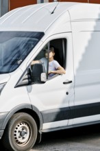 Young woman delivery courier driving a van