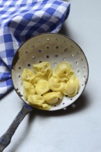 Cappelletti, cooked pasta in a sieve ladle, pasta