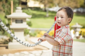 Young chinese and caucasian boy having fun at the park