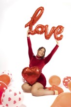 Studio portrait of beautiful woman in red dress on white background holding sign with word love.