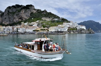 Tour boat in front of town Amalfi, Amalfi Coast, Costiera Amalfitana, Province of Salerno,