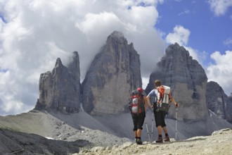 Couple mountain walkers admiring the Tre Cime di Lavaredo, Drei Zinnen, Dolomites, Italy, Europe