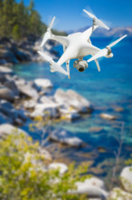 Unmanned aircraft system (UAV) quadcopter drone in the air over lake tahoe