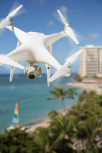 Unmanned aircraft system (UAV) quadcopter drone in the air over waikiki beach in hawaii