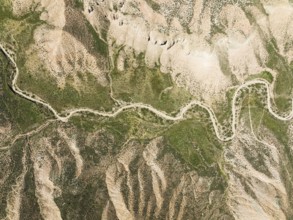 Dirt road in the Gorafe Desert with green surroundings after some rainfalls, aerial view, drone