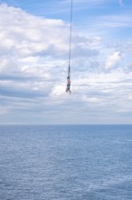 Bungy jumper on the rope over the sea, The Hague, Netherlands