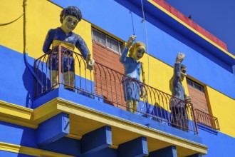 Footballer Diego Maradona, folk heroine Eva Perón and tango singer Carlos Gardel on a balcony,