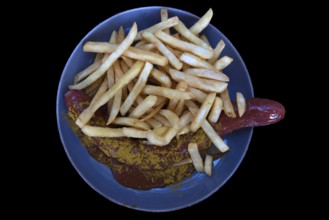 Currywurst with fries on a black background, Bavaria, Deutschalmd