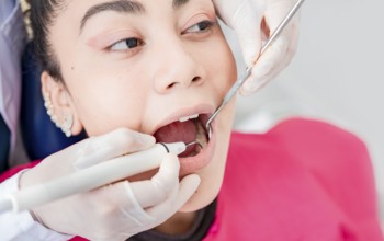 Close up of dentist checking patient with excavator and dental mirror, Dentist checking patient