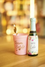 Team bride cup and a love champagne standing on a table