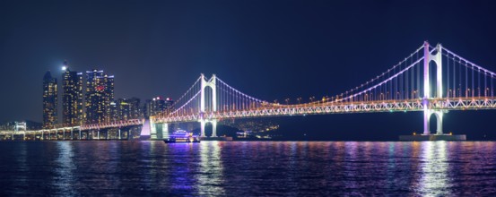 Panorama of Gwangan Bridge and skyscrapers illuminated in the night. Busan, South Korea, Asia