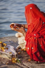 MAHESHWAR, INDIA, APRIL 26: Indian woman performs morning pooja on sacred river Narmada ghats on