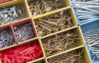 Colourful carpentry box of metal screws viewed from above