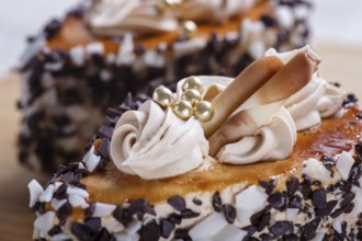 Cakes with chocolate chips and cream decorations on wooden board on white background. selective