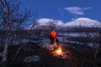 Man at the campfire, Stora Sjöfallet National Park, World Heritage Laponia, Norrbotten, Lapland,