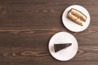 Chocolate biscuit cake with caramel cream on brown wooden background. top view, flat lay, copy