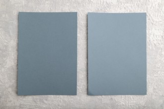 Blue paper business card, mockup on gray concrete background. Blank, flat lay, top view, still