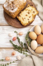 Homemade easter pie with raisins and eggs on plate on a white wooden background and linen textile.