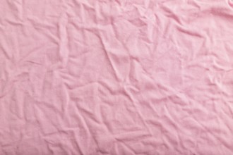 Fragment of pink cotton tissue. Top view, flat lay, natural textile background and texture