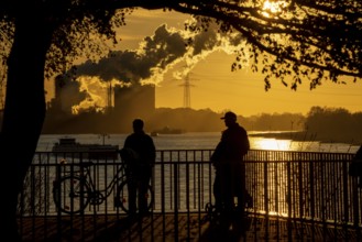 Rhine promenade in Duisburg-Wanheim, sunset, view of the Rhine and Hüttenwerke Krupp Mannesmann,