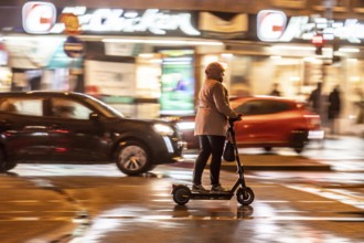 Street at the main station, e-scooter driver, rainy weather, city centre, in the evening, Essen,