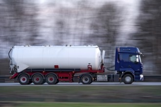 Truck, lorry, articulated lorry with tanker trailer driving fast on the A92 motorway, motion blur,