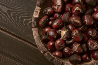 Roasted chestnuts, in a wooden plate, top view, homemade, no people