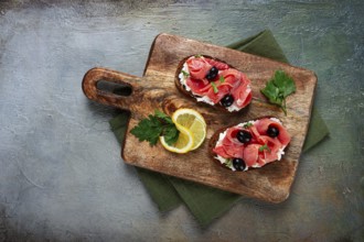 Sandwiches with cream cheese, chum salmon, cold smoked, grain bread, on a cutting board, top view,