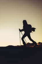 A woman's ski tour at sunrise on the Tegelberg in the Allgäu in the Ammergebirge, Bavaria, Germany,