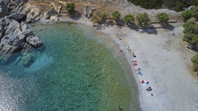 Palatia Beach, Palatia, people relaxing on a small, quiet beach with turquoise blue water and