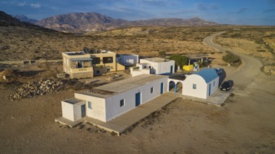 Small Mediterranean-style houses in a rural desert landscape, blue and white Agios Theodoros