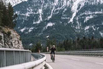 Road bike rider in spring in the Allgäu against the picturesque backdrop of the Alps, Bavaria,