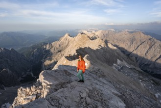 Mountaineer on a steep rocky ridge, impressive mountain landscape, view of the Höllental and the