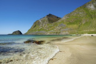 Landscape with sea at the sandy beach of Haukland with the mountain Veggen. Shot during the day