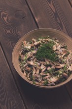 Chicken and mushroom salad, with herbs, seasoned with white sauce, close-up, rustic style, on a