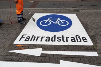 Application of road markings for a cycle lane, Rüttenscheider Straße in Essen, in the shopping and