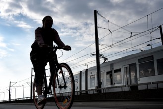 Cycling in the city, cyclist on the Deutzer Bridge in Cologne, tram, cycle path, North