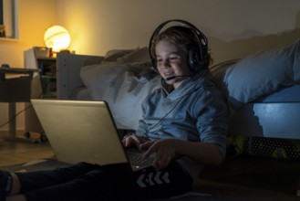 Boy, at home on the computer, laptop, in the children's room, playing a game, chatting with other