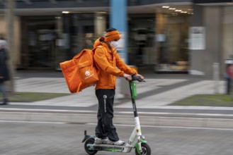 Delivery service Lieferando.de, delivery courier with e-scooter in the city centre, Rathenaustraße,