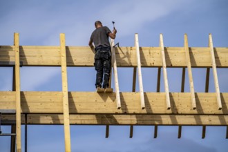 Carpenter, on a roof truss, new construction of a wooden pointed roof, renovation