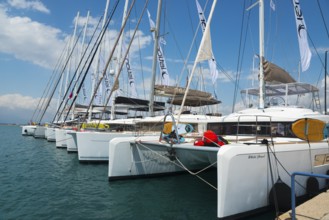 Row of catamarans in the harbour with clear blue sky and calm sea, Mediterranean yacht show,