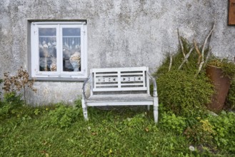 Bench in front of a whitewashed house wall with window in Varel, district of Friesland, Lower