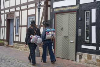 Travelling craftsmen on the road through half-timbered alley Rinteln Germany