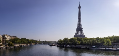 The Eiffel Tower on the banks of the Seine under a clear blue sky, Paris