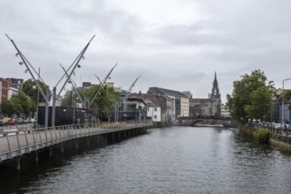 View of a river with modern architecture and clouds above, Cork