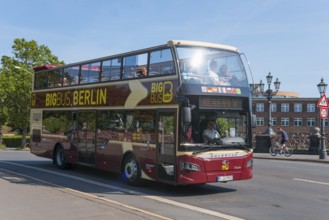 A red Berlin sightseeing double-decker bus on a street, full of tourists, double-decker bus,